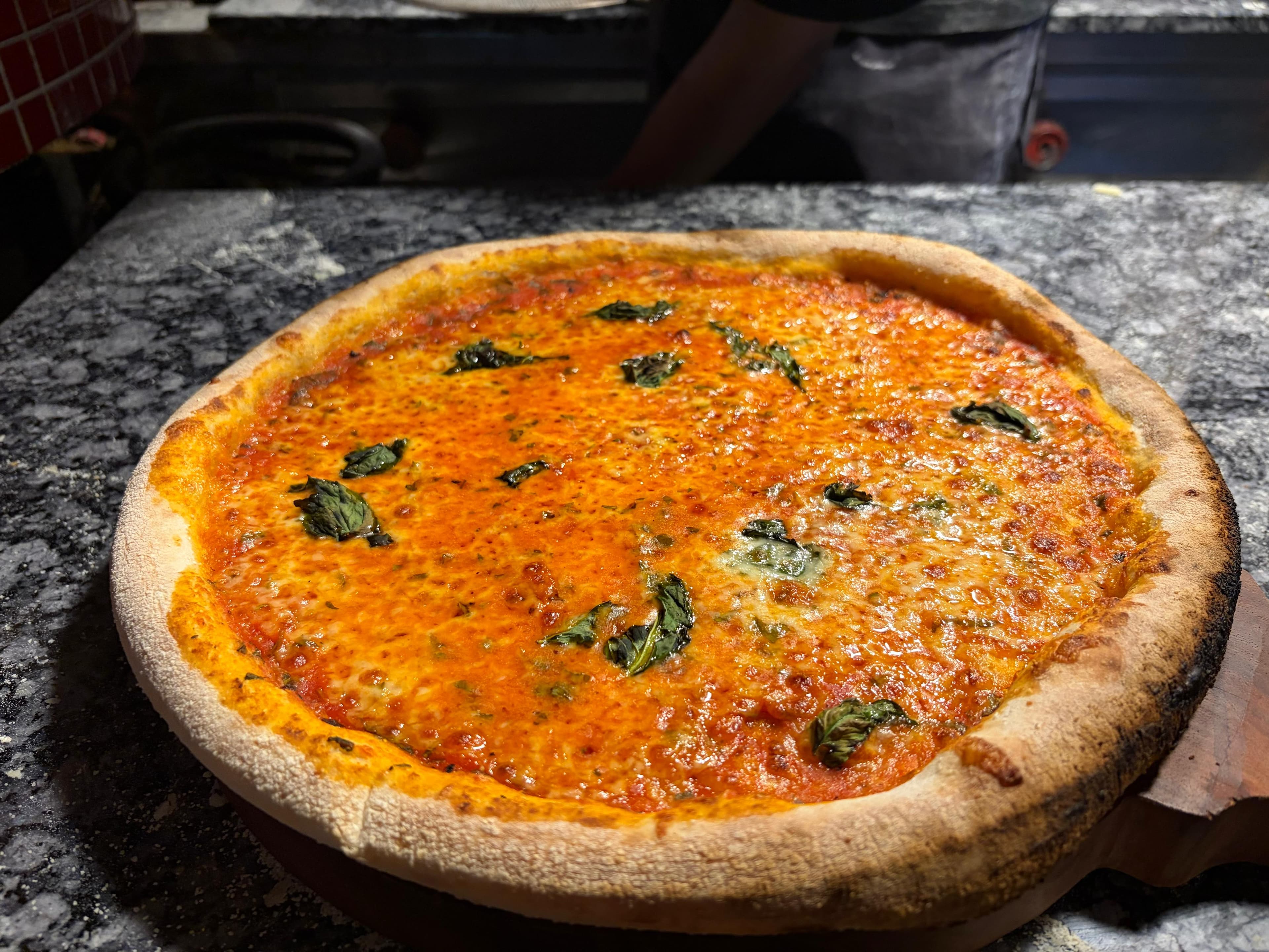 Indiella authentic Classic Margherita pizza on wooden peel showing blistered cornicione